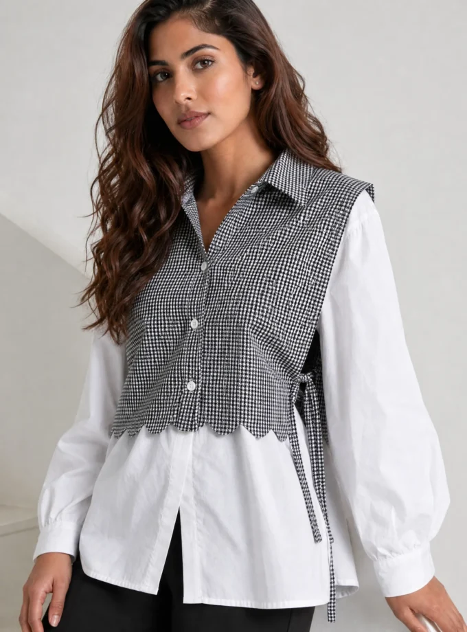 Breeze — model wearing the white round neck button down shirt with the black and white houndstooth print bib with side tie up
