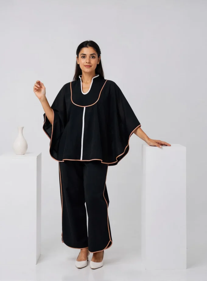 Charm — model wearing the black h-loom umbrella yoke top with raining edging paired with the black h-loom straight fit pant