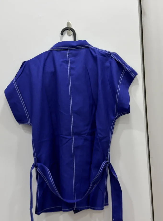 Cobalt blue overlap collar top with belt shown alone on a hanger