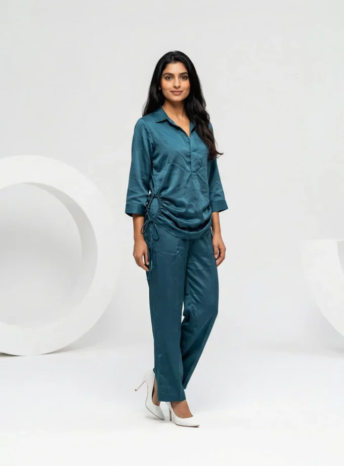 Elise — model wearing the teal cotton mandarin button down shirt with a hollow hem and matching teal straight fit pants