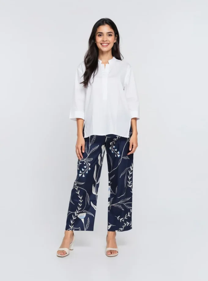 Estelle — model wearing the white cotton mandarin button down shirt with a hollow hem and the blu forest print glaze cotton straight fit pants
