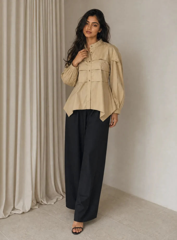 Grace — model wearing the beige cotton closed neck button down flat pleat shirt with balloon sleeves